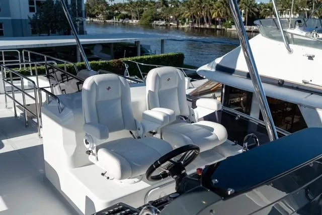 Freedom Yacht Photos Pics Flybridge of 2022 Sirena 58 yacht with dual captain chairs and scenic waterway view.