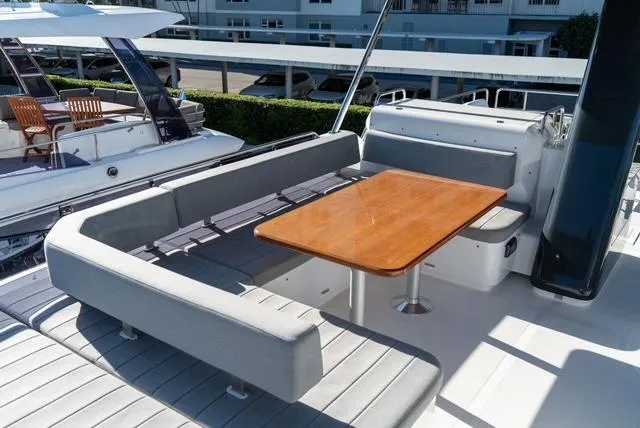 Freedom Yacht Photos Pics 2022 Sirena 58 Flybridge yacht with elegant outdoor seating and wooden table.