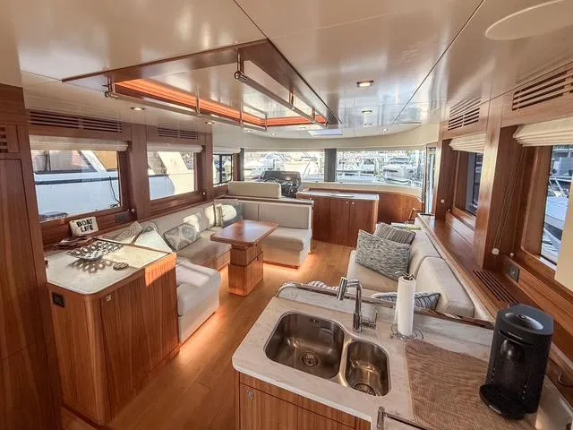 Freedom Yacht Photos Pics Luxurious interior of 2022 Sirena 58 Flybridge yacht with modern wood finishes and spacious seating.