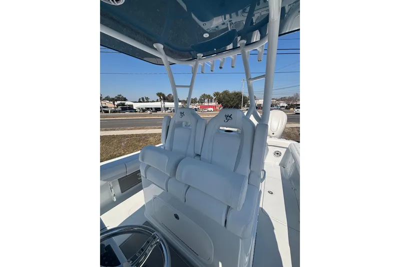  Yacht Photos Pics 2026 Yellowfin 36 Offshore boat with white seating and steering wheel, parked outdoors.