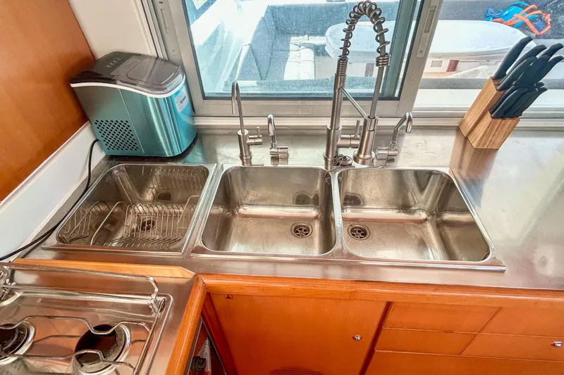 Sailifi Yacht Photos Pics Modern kitchen sink setup in a 2007 Lagoon 440 catamaran, featuring dual basins and a sleek faucet.