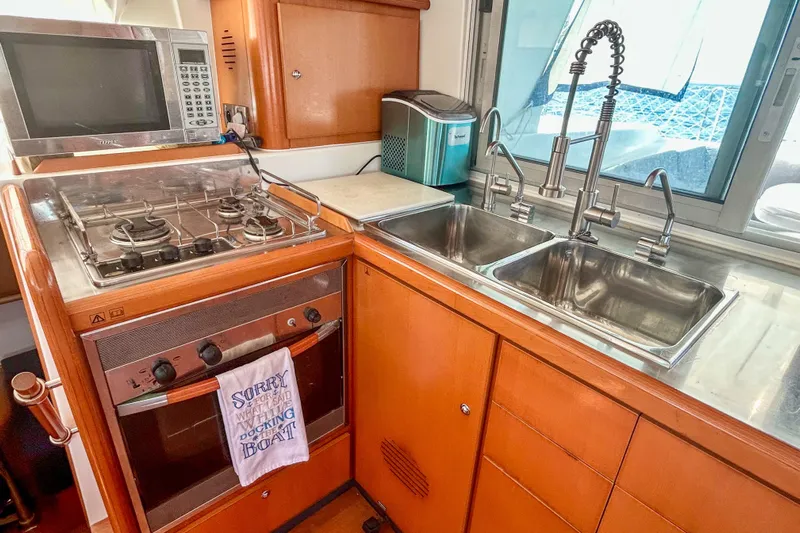 Sailifi Yacht Photos Pics Kitchen area of a 2007 Lagoon 440 yacht with stove, oven, and dual sinks.