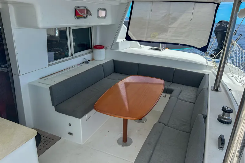 Sailifi Yacht Photos Pics Spacious seating area on 2007 Lagoon 440 catamaran with wooden table and ocean view.