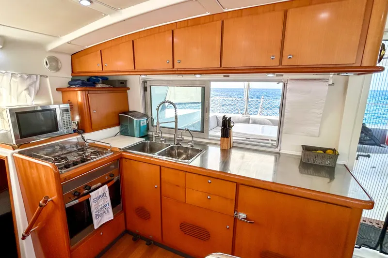 Sailifi Yacht Photos Pics Interior of 2007 Lagoon 440 yacht kitchen with stove, sink, and ocean view.