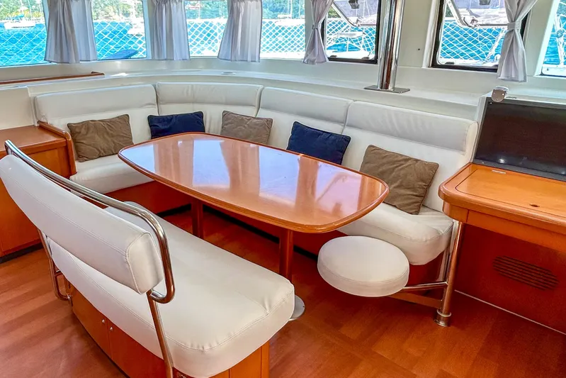 Sailifi Yacht Photos Pics Interior of 2007 Lagoon 440 yacht with elegant seating and wooden table.