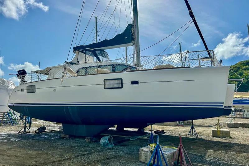 Sailifi Yacht Photos Pics 2007 Lagoon 440 catamaran on land, with blue sky and clouds in the background.