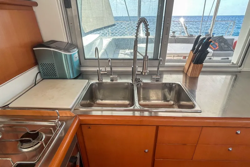 Sailifi Yacht Photos Pics Interior of 2007 Lagoon 440 yacht kitchen with double sink and ocean view.