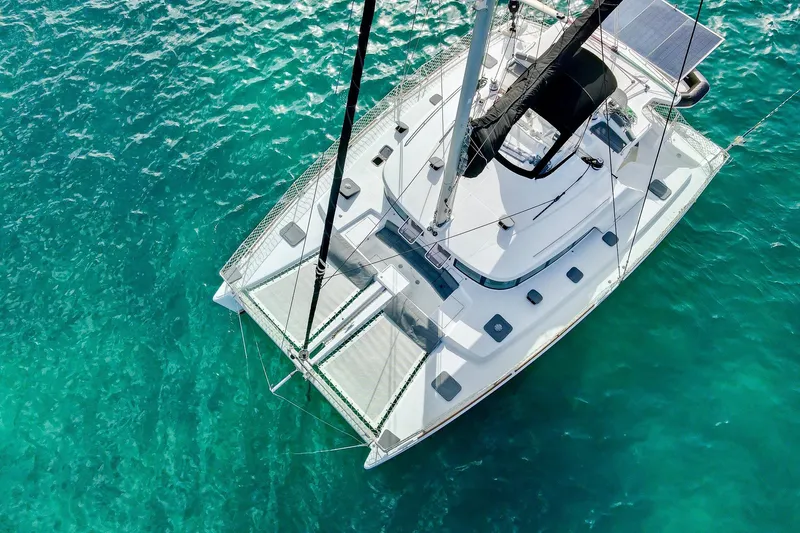 Sailifi Yacht Photos Pics Aerial view of 2007 Lagoon 440 catamaran sailing on clear turquoise waters.