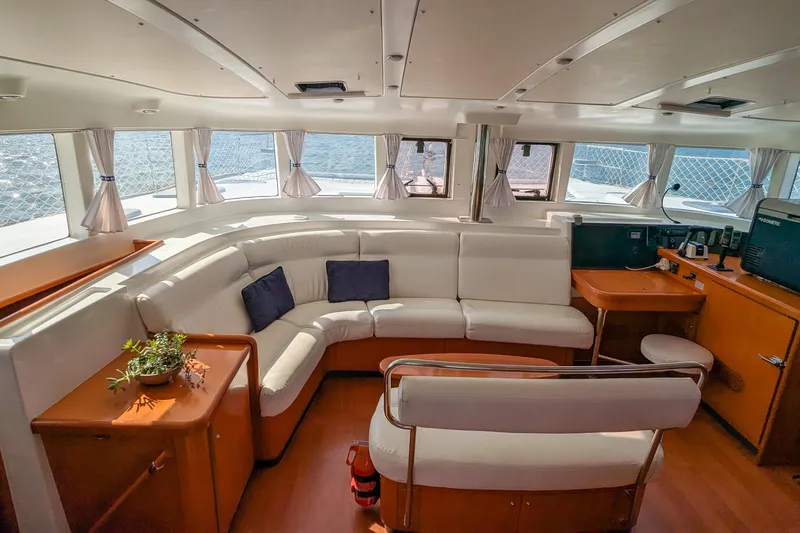 Sailifi Yacht Photos Pics Interior of 2007 Lagoon 440 catamaran with white seating and wooden accents.