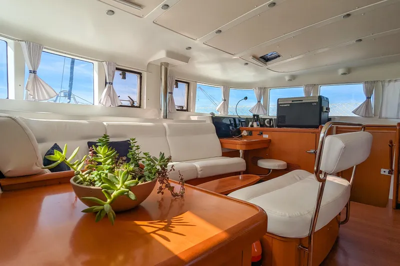 Sailifi Yacht Photos Pics Luxurious interior of 2007 Lagoon 440 catamaran with white seating and potted plants.