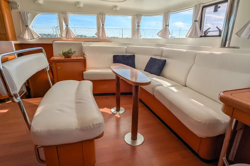 Sailifi Yacht Photos Pics Interior of 2007 Lagoon 440 catamaran with white seating and wooden accents.