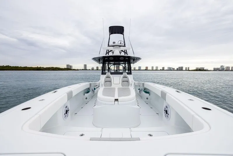Never Enough Yacht Photos Pics 2025 Freeman 38 boat on water, sleek design, spacious deck, city skyline in background.