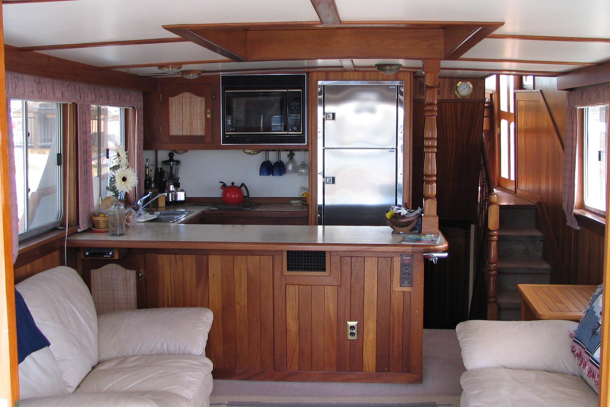 Interior of 1989 Custom 52 Pilothouse with wooden kitchen and cozy seating area.