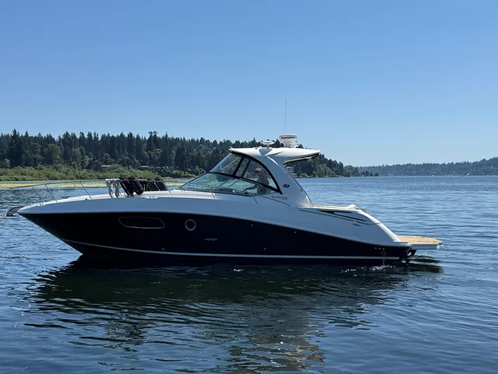  Yacht Photos Pics 2012 Sea Ray 370 Sundancer yacht cruising on a serene lake under clear blue skies.