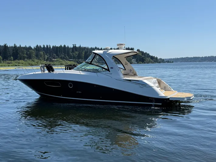  Yacht Photos Pics 2012 Sea Ray 370 Sundancer yacht cruising on a serene lake under clear blue skies.