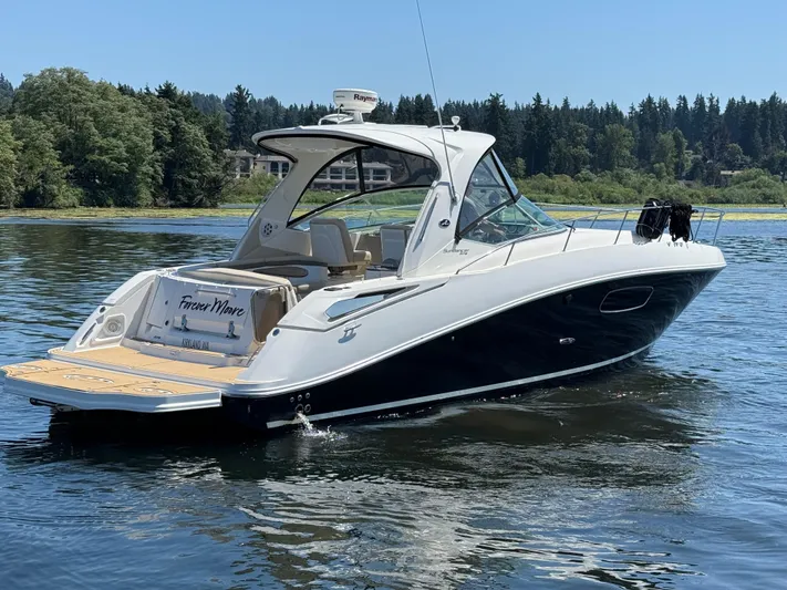  Yacht Photos Pics 2012 Sea Ray 370 Sundancer boat on a serene lake with forested background.