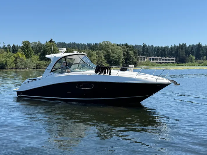  Yacht Photos Pics 2012 Sea Ray 370 Sundancer yacht on a serene lake with lush greenery.