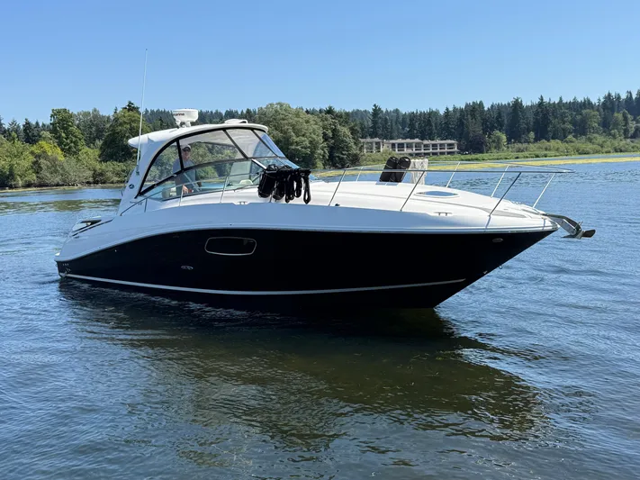  Yacht Photos Pics 2012 Sea Ray 370 Sundancer cruising on a serene lake with forested shoreline.