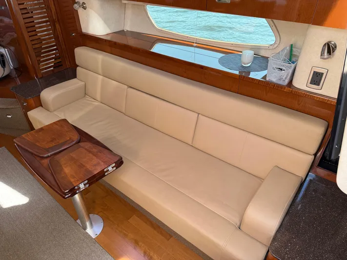  Yacht Photos Pics Luxurious interior of 2012 Sea Ray 370 Sundancer with beige leather seating and wooden accents.