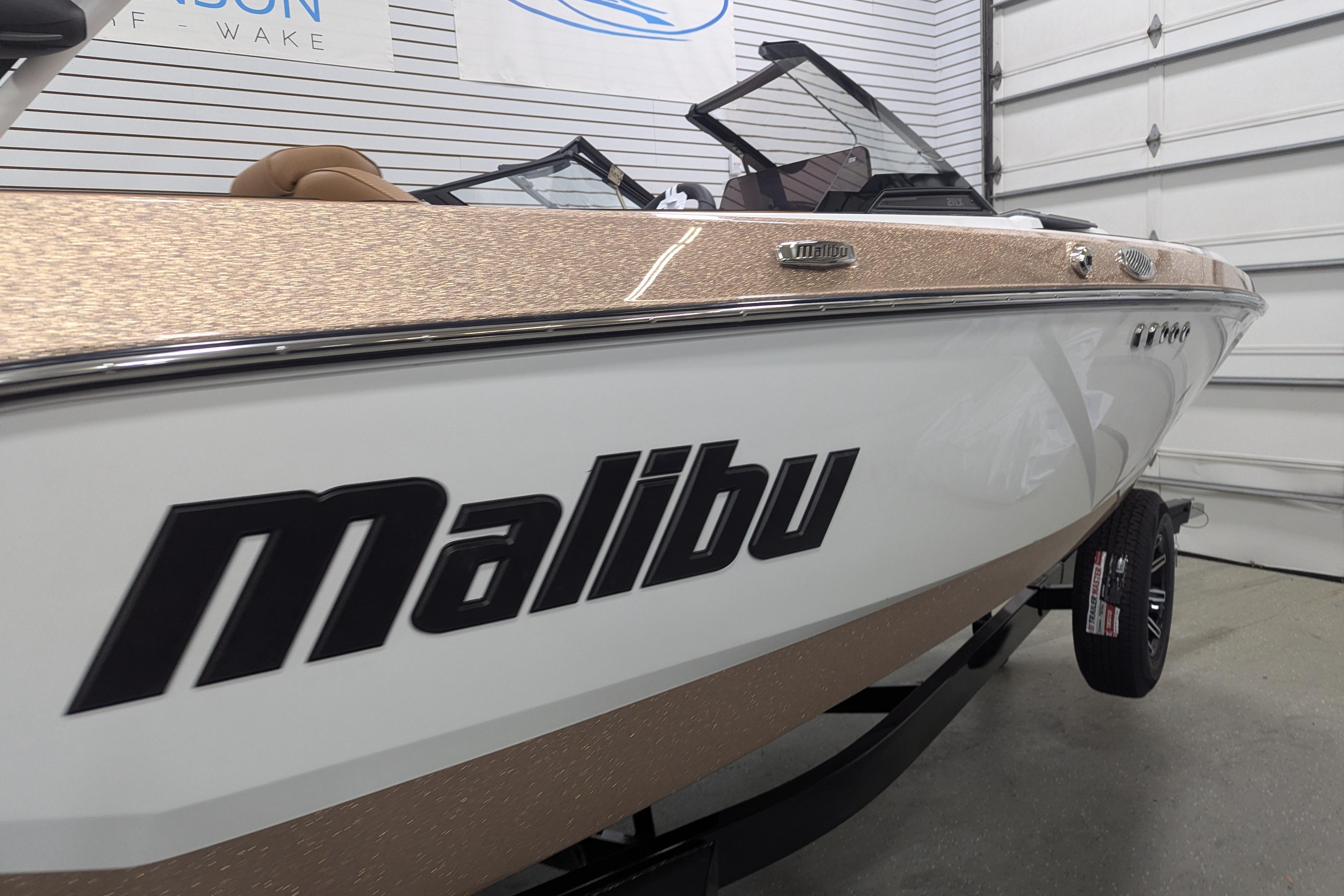 2026 Malibu Wakesetter 21 LX boat in showroom, featuring sleek design and branding.