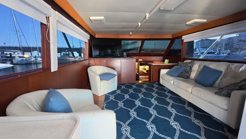 Lochloosa Yacht Photos Pics 1979 Hatteras Sportfish interior with plush seating, nautical decor, and marina view.