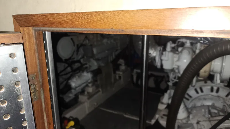 Orly Yacht Photos Pics Engine room of a 1990 President 465 yacht, featuring mechanical components and wooden framing.