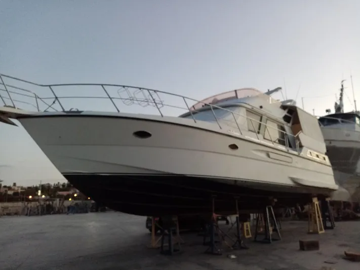 Orly Yacht Photos Pics 1990 President 465 yacht on dry dock at sunset, showcasing sleek design and structure.