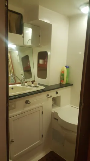 Orly Yacht Photos Pics Compact bathroom in a 1990 President 465 yacht, featuring sink, mirror, and storage.
