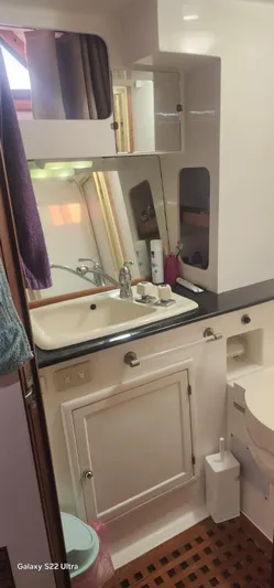 Orly Yacht Photos Pics Compact bathroom in a 1990 President 465 yacht, featuring a sink, mirror, and storage cabinets.