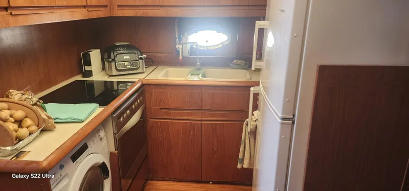 Orly Yacht Photos Pics Compact wooden kitchen in a 1990 President 465 yacht with modern appliances.
