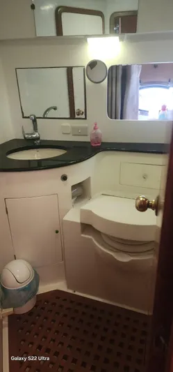 Orly Yacht Photos Pics Compact yacht bathroom with sink, mirror, and toilet in a 1990 President 465 model.