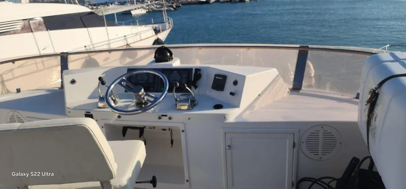 Orly Yacht Photos Pics Helm of 1990 President 465 yacht with steering wheel and controls, docked at marina.