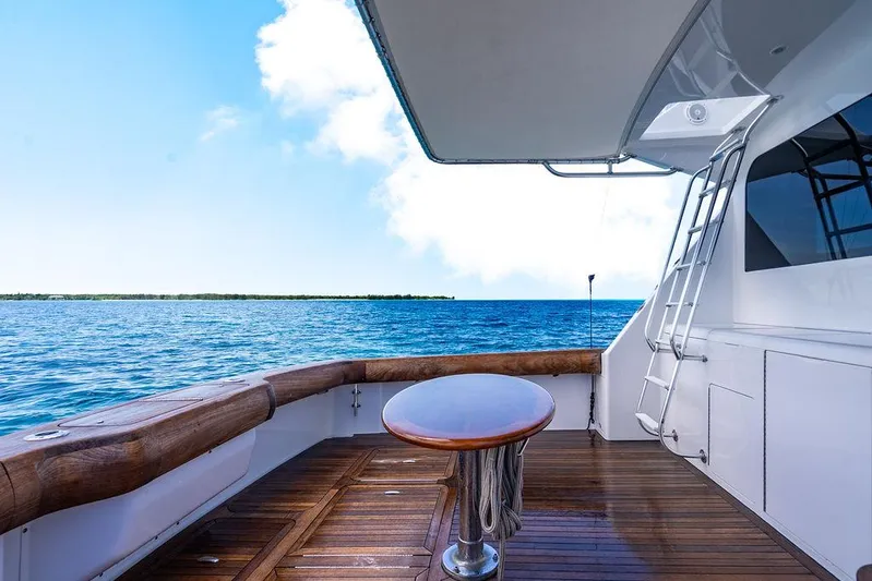  Yacht Photos Pics 1999 Viking Convertible yacht deck with ocean view, featuring wooden flooring and a ladder.