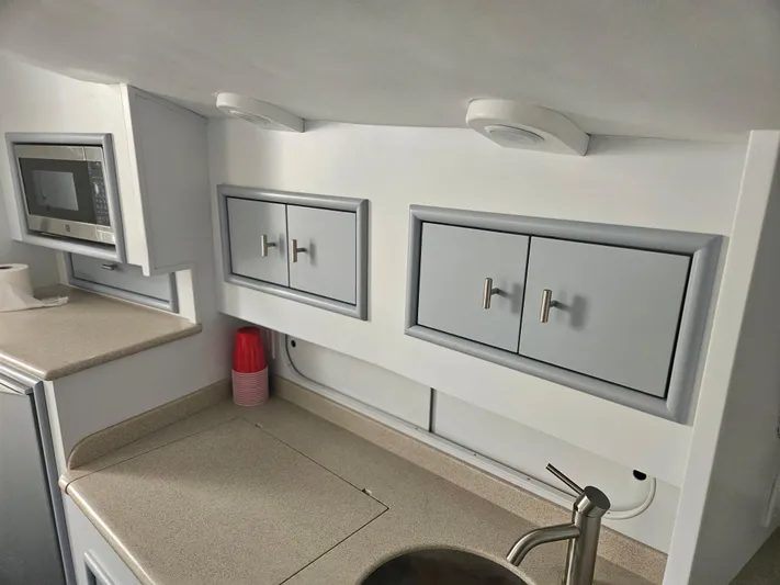 Yacht Photos Pics 1996 Blackfin 33 Combi interior kitchen with cabinets, microwave, and sink.