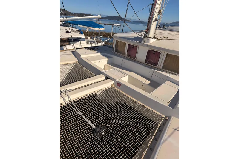  Yacht Photos Pics 2010 Lagoon 440 catamaran deck with netting, docked by the sea.