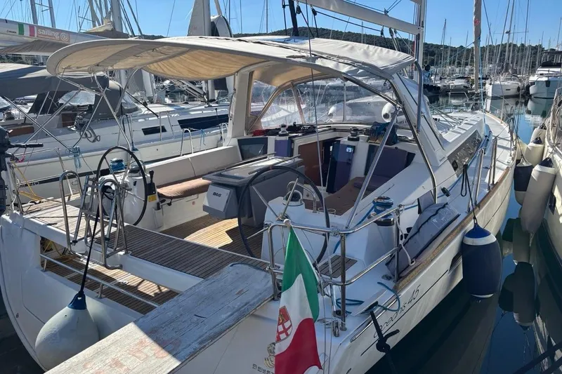  Yacht Photos Pics 2019 Beneteau Oceanis 45 sailboat docked in marina, featuring spacious cockpit and Italian flag.