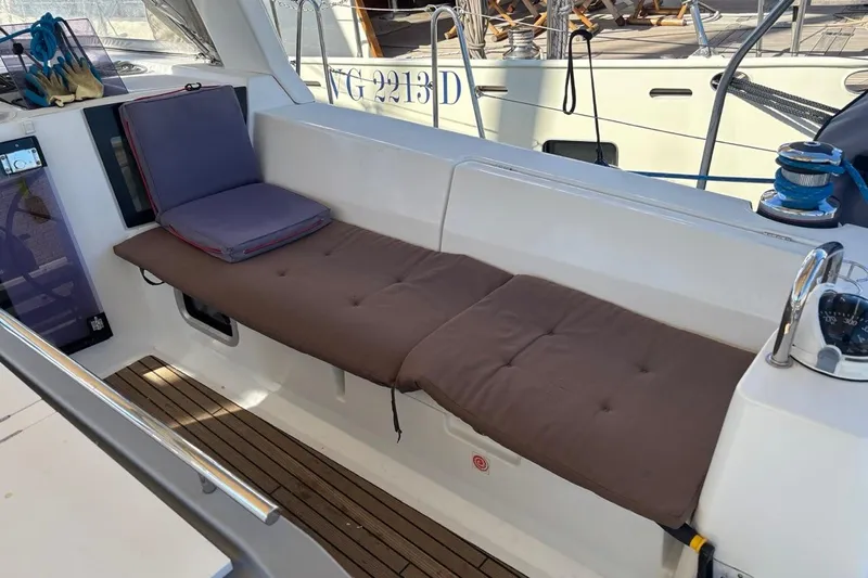  Yacht Photos Pics 2019 Beneteau Oceanis 45 yacht cockpit with cushioned seating and wooden flooring.