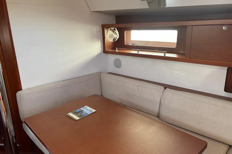  Yacht Photos Pics Interior of 2019 Beneteau Oceanis 45 yacht with cozy seating and wooden table.