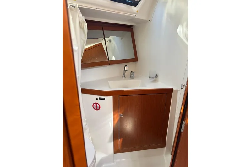  Yacht Photos Pics Bathroom interior of 2019 Beneteau Oceanis 45 yacht with wooden cabinetry and mirror.