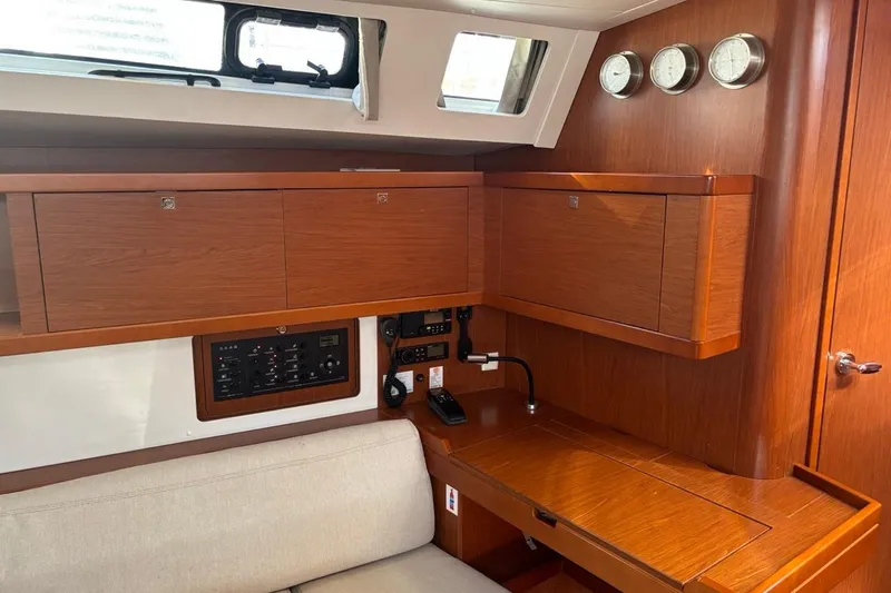  Yacht Photos Pics Interior of 2019 Beneteau Oceanis 45 yacht with wooden cabinetry and navigation instruments.