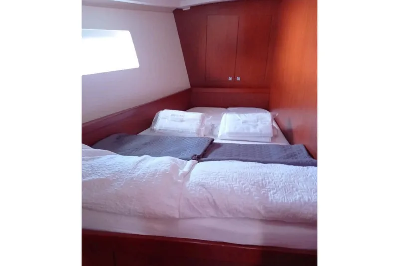  Yacht Photos Pics Cozy cabin interior of 2019 Beneteau Oceanis 45 sailboat with comfortable bedding.