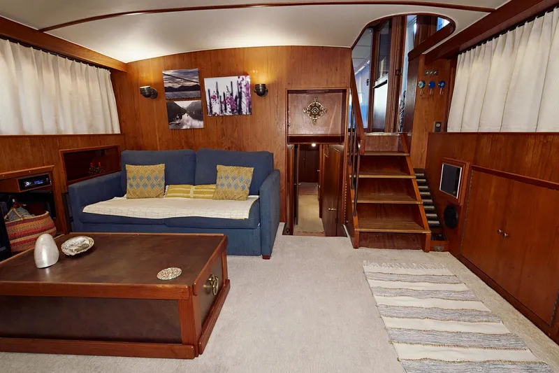 Camelot Yacht Photos Pics Interior of a 1976 Pacemaker 65 yacht with wooden paneling and cozy seating area.