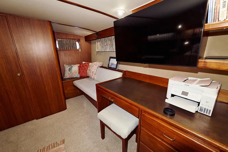 Camelot Yacht Photos Pics 1976 Pacemaker 65 yacht interior with desk, seating area, and TV.