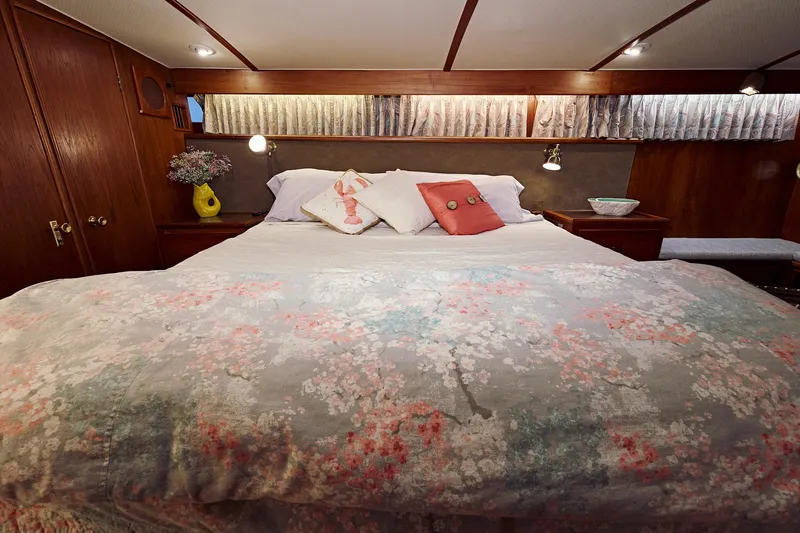 Camelot Yacht Photos Pics Cozy bedroom in a 1976 Pacemaker 65 yacht with floral bedding.