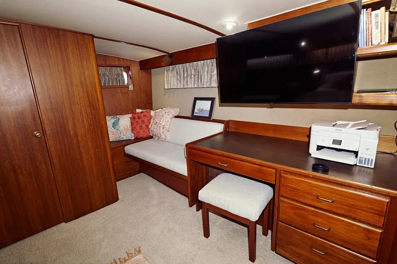 Camelot Yacht Photos Pics 1976 Pacemaker 65 interior with wooden furniture, desk, TV, and seating area.
