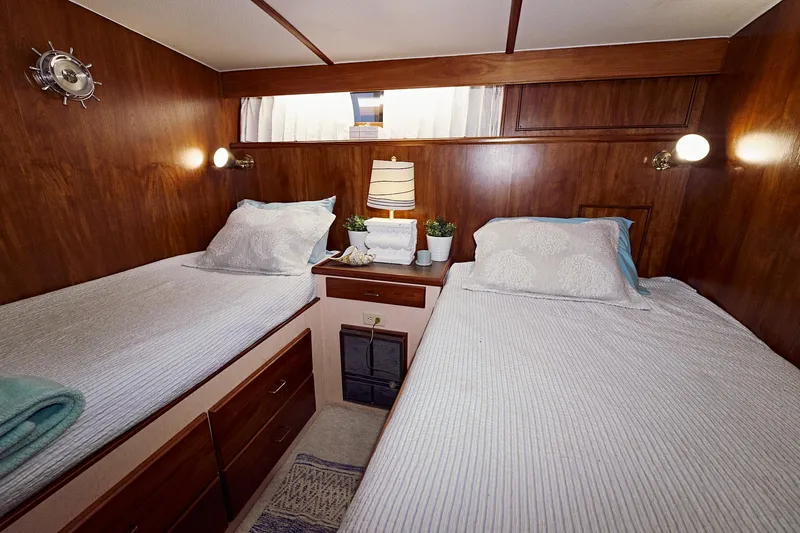 Camelot Yacht Photos Pics Twin bed cabin interior of 1976 Pacemaker 65 yacht with wooden paneling.