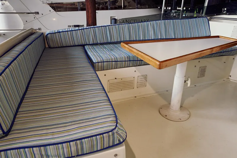 Camelot Yacht Photos Pics 1976 Pacemaker 65 boat interior with striped seating and table.
