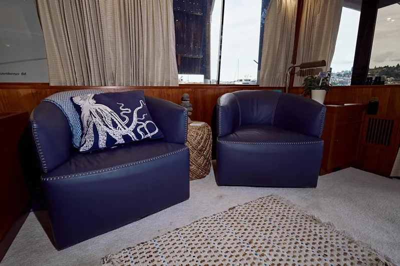 Camelot Yacht Photos Pics 1976 Pacemaker 65 yacht interior with blue leather chairs and octopus pillow.