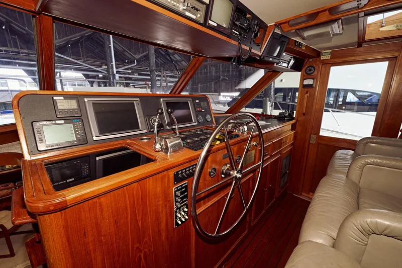 Camelot Yacht Photos Pics 1976 Pacemaker 65 yacht helm with wooden dashboard and modern navigation equipment.