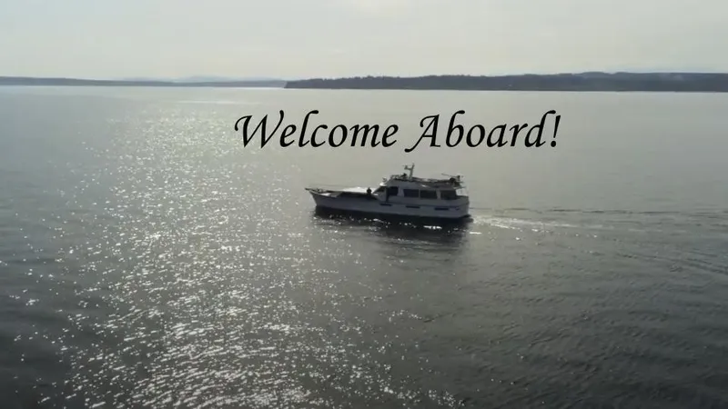 Camelot Yacht Photos Pics 1976 Pacemaker 65 yacht cruising on serene waters with 'Welcome Aboard!' text.